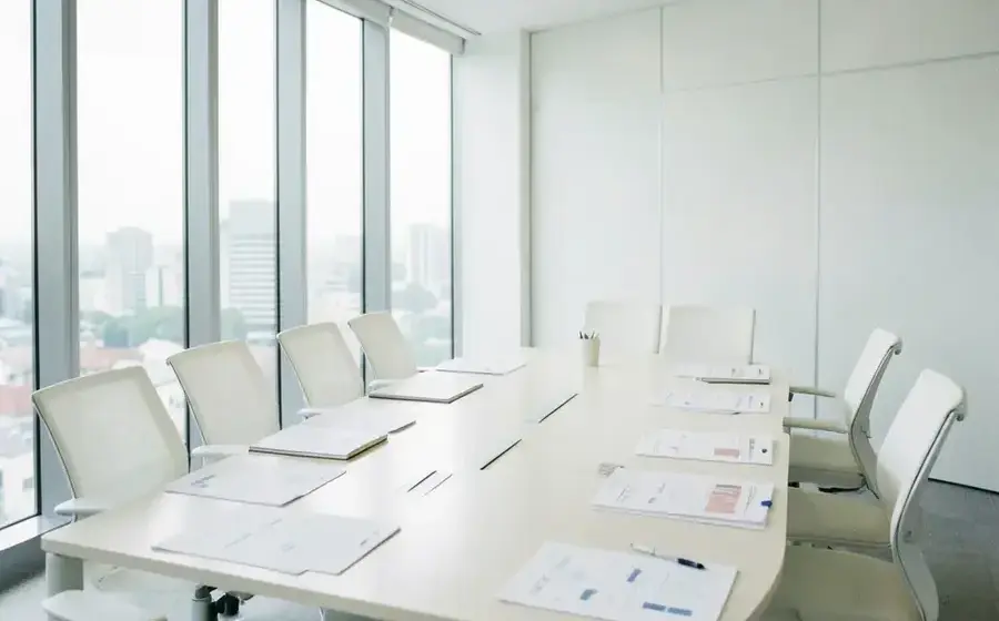 白い壁の会議室で資料を広げる様子